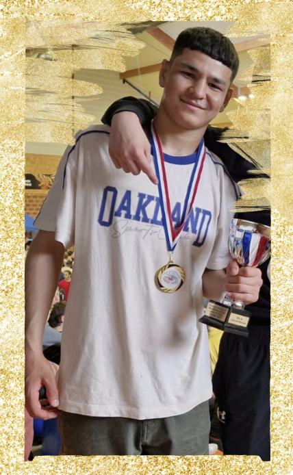 Mostafa Mohammadi pose avec une médaille d'or autour du cou et une coupe dans la main, après sa victoire au Challenge international Beaugrand-Jacob. Il sourit modestement, vêtu d'un t-shirt clair, entouré de camarades.
