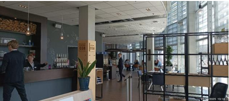 Cette photo montre l'entrée d'un restaurant d'application au Deltion College. On peut y voir un espace moderne et accueillant avec un comptoir où les étudiants accueillent les clients.