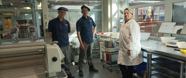 Cette image montre un laboratoire de pâtisserie équipé de machines professionnelles, et l'équipe de pâtisserie (2 hommes et 1 femme).