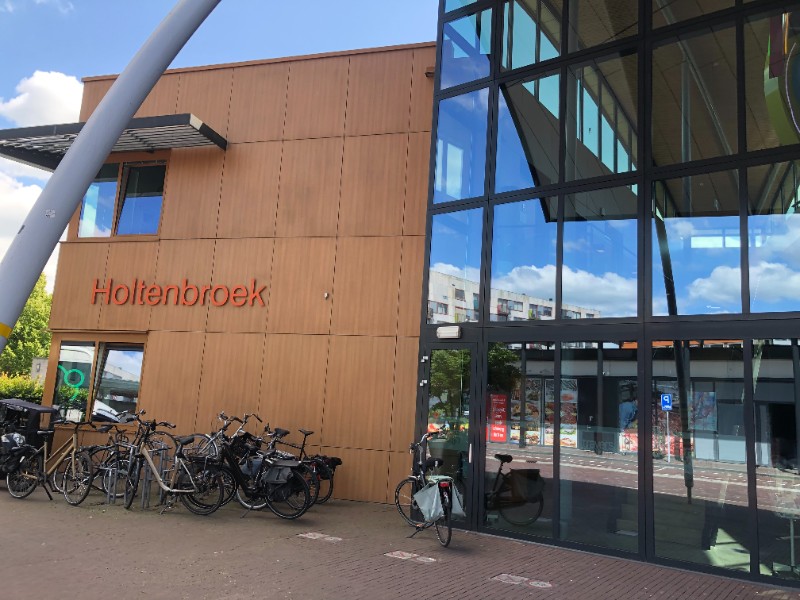 Centre social de Holtenbroek à Zwolle, bâtiment moderne avec façade en bois et vitrages, stationnement de vélos au premier plan.